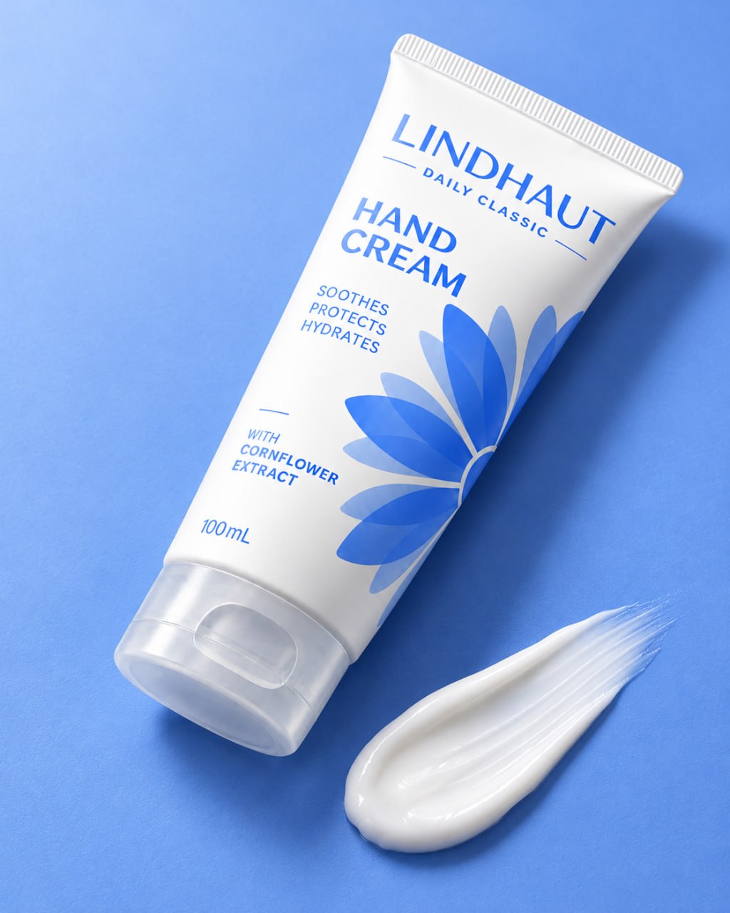 LINDHAUT Daily Classic tube lying on blue with a swatch of white cream beside it